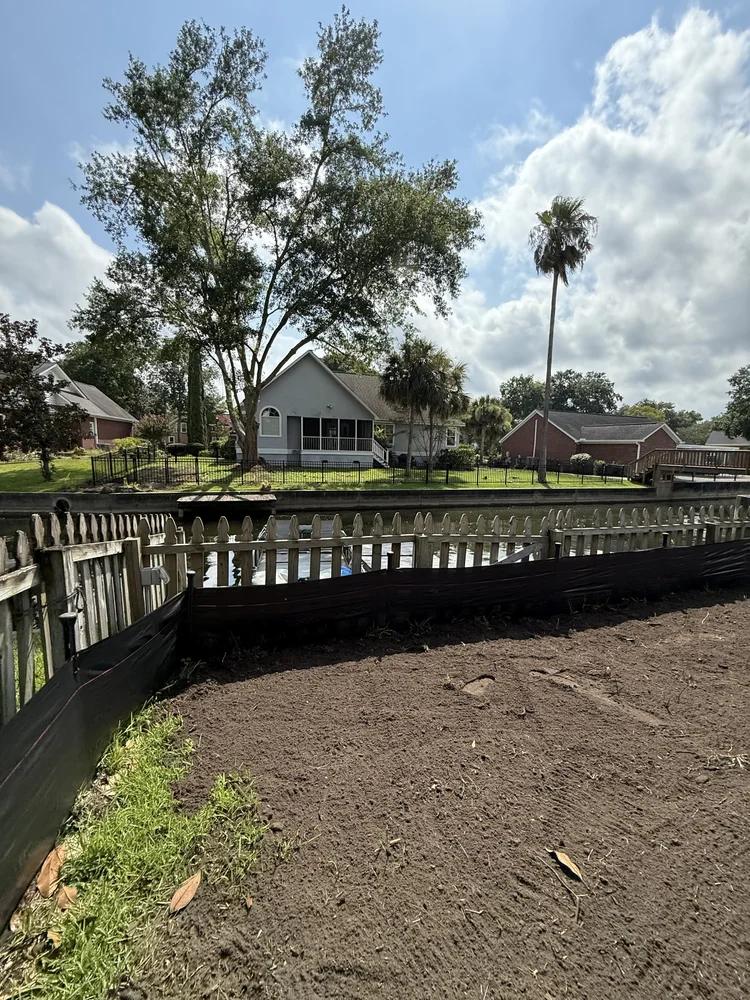 Black silt fence installed around a waterfront residential project